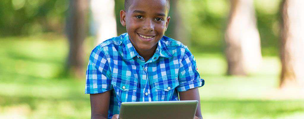 Boy sitting outside using iPad