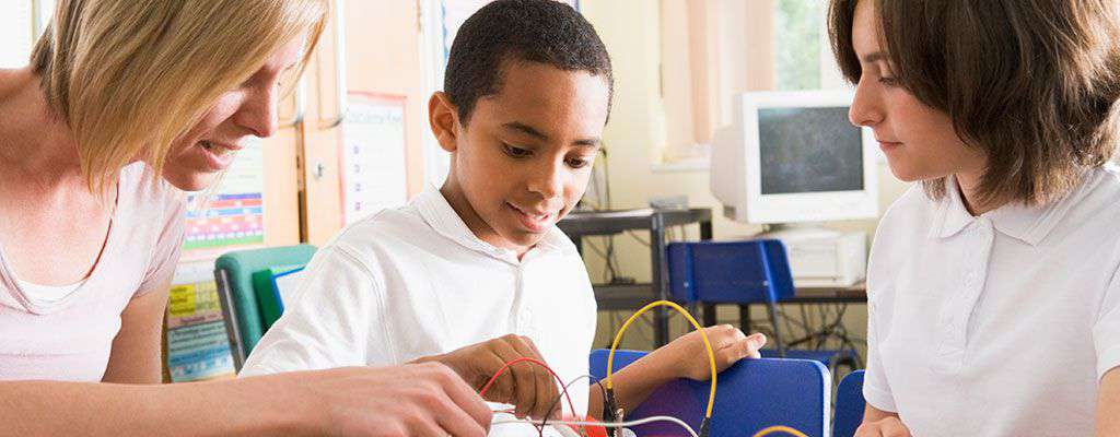 Young student working with teacher on electronic project